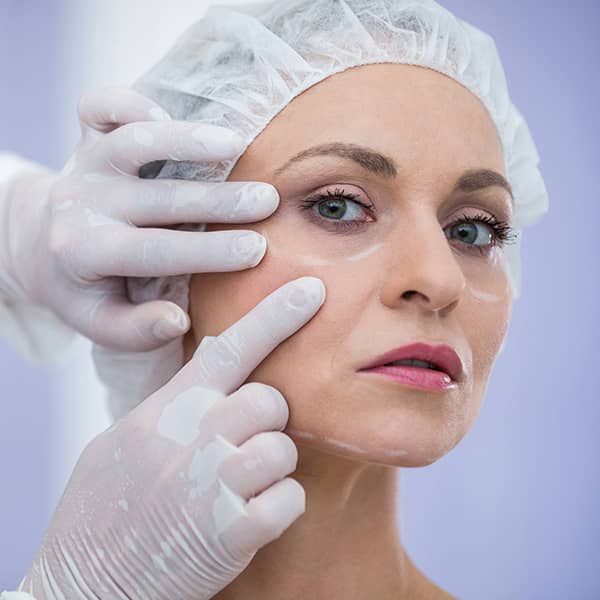 A Cosmetic Surgeon examining a woman's face before a facelift procedure